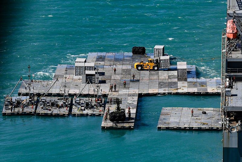 Army mariners work to construct a causeway adjacent to the MV Maj. Bernard F. Fisher off the coast of Bowen, Australia, July