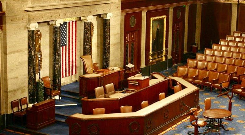 An interior view of the chamber of the US House of Representatives in the US Congress with an American flag displayed promine