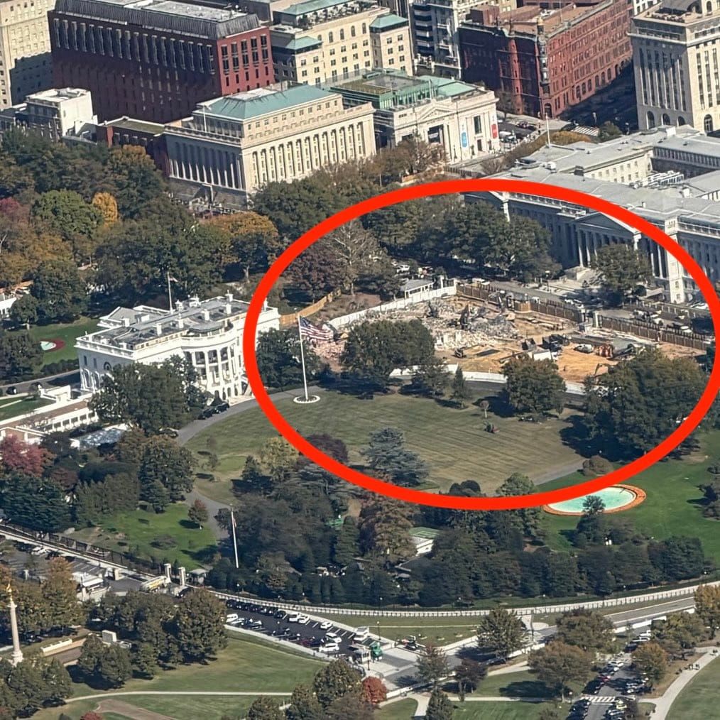 Aerial view of the White House and surrounding area, with a red circle highlighting a de/construction site where the East Wing previously was and green space.
