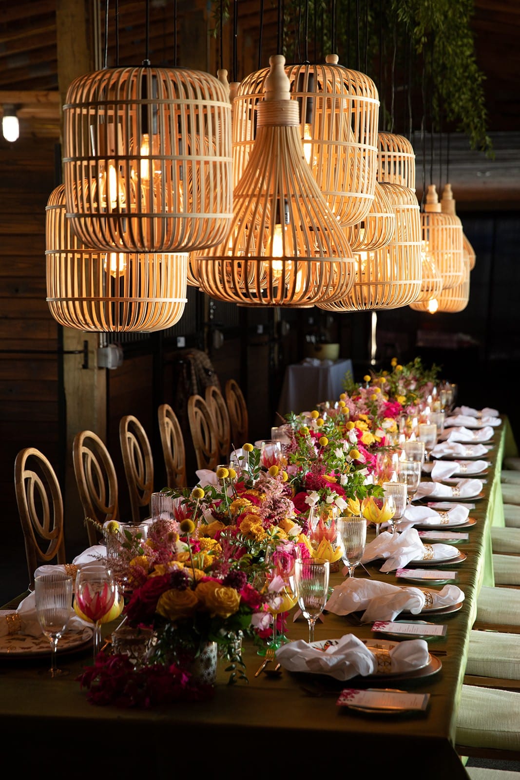 Rattan chandeliers over a long, colorful tablescape