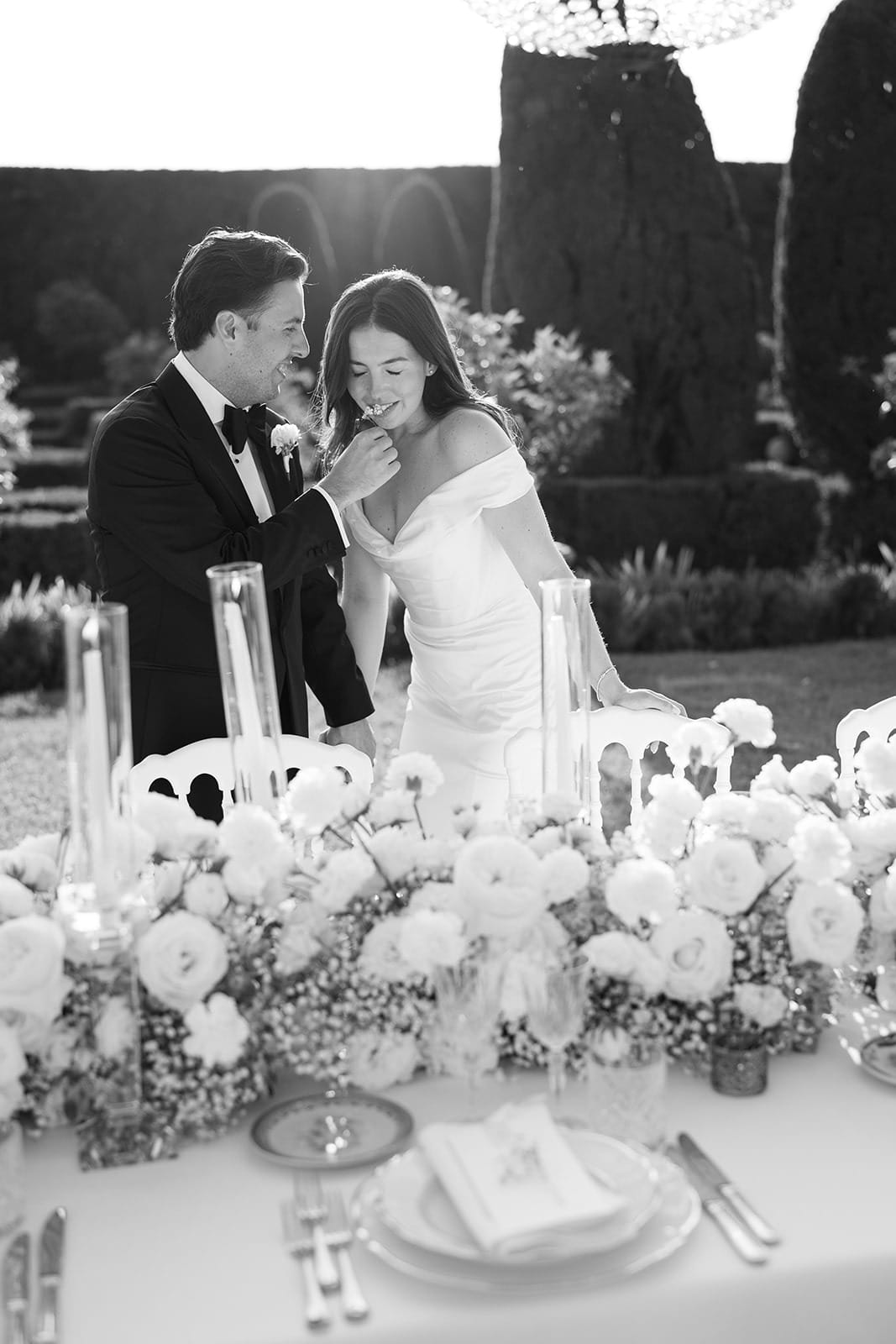 Black and white portrait of a couple seated at a garden dinner table