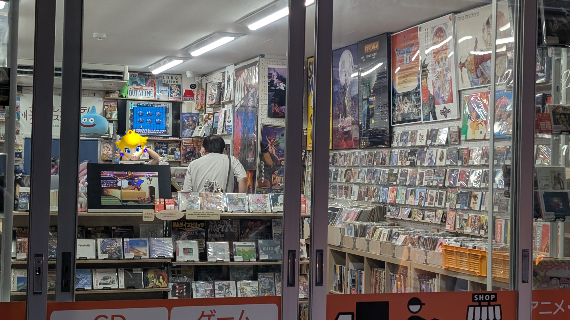 A look at Rare Item Studio from the outside. A man is shopping inside the store, which with games, and a woman is at the check out.