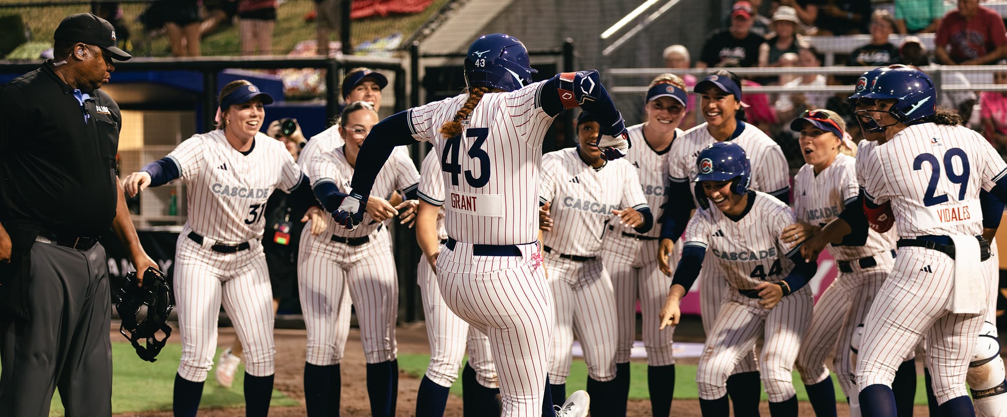 Portland Cascade slugger Megan Grant (43) greeted at the plate by teammates after a home run