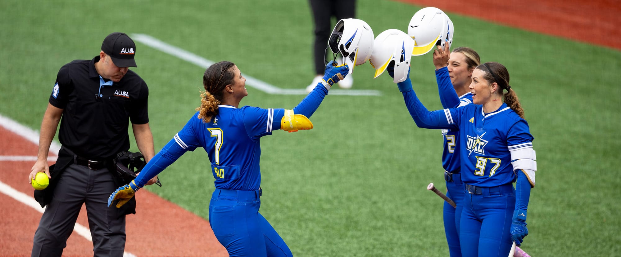 Oklahoma City's Maya Brady (7) taps helmets with teammates after a home run