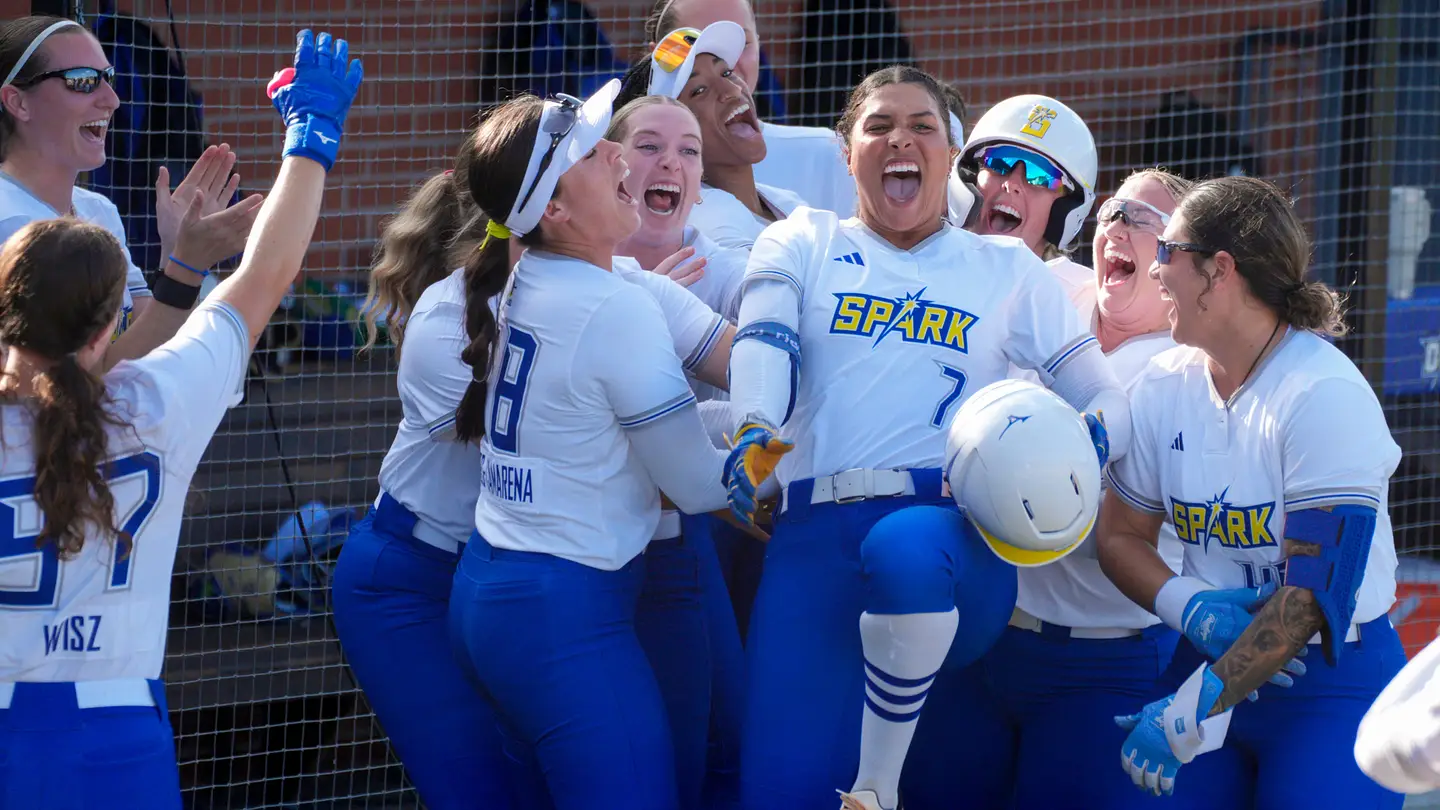 OKC Spark players celebrate at the dugout fence
