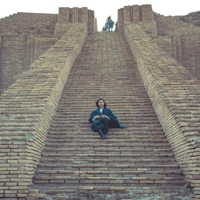 Woman sittings on the access staircase of the ziggurat of Ur in Iraq