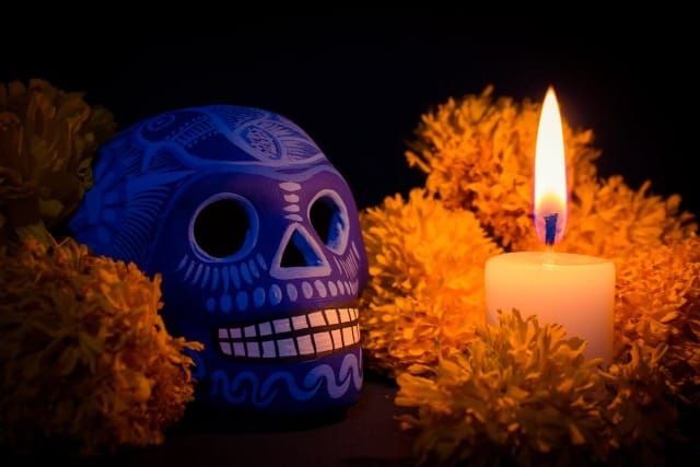 Photo of a painted skull with a candle and flowers
