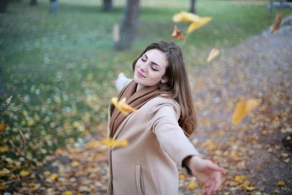 Photo of a woman with open arms and smiling with eyes closed