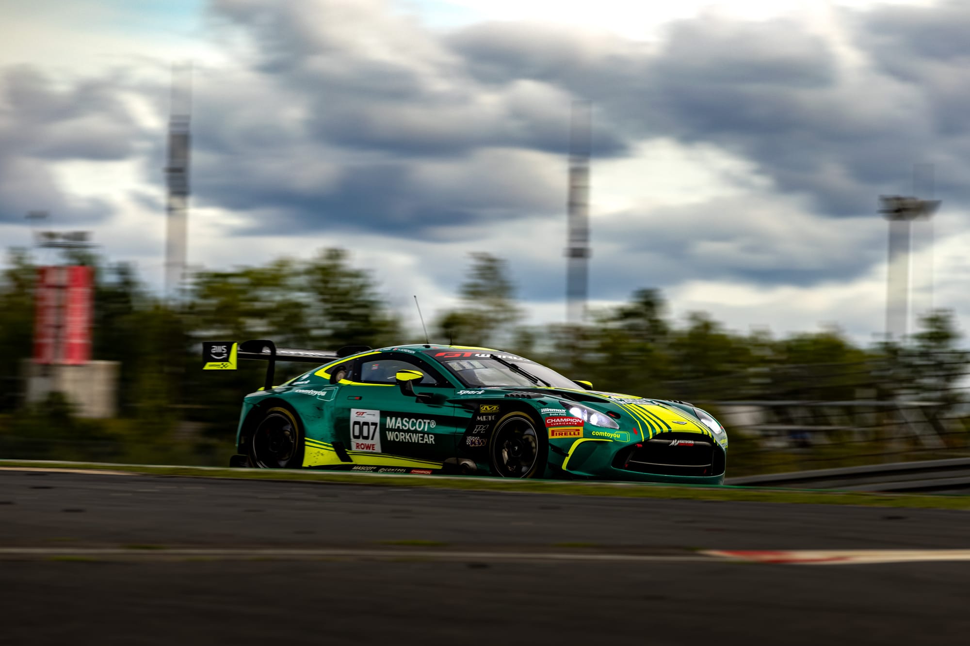 Number 7 Comtoyou Racing Aston Martin Vantage AMR GT3 EVO racing at speed on the Nürburgring Grand Prix circuit.