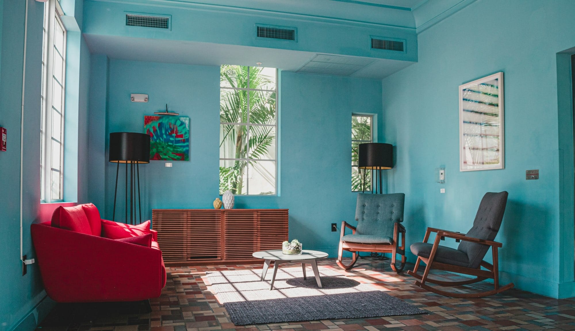 upholstered wooden rocking chair near green potted plant; Photo by Juan Rojas / Unsplash