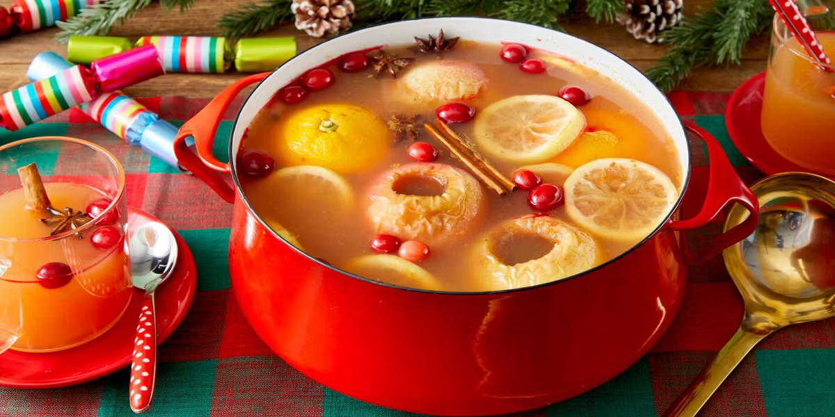 Wassail in a red pot on a green and red checked Christmas tablecloth