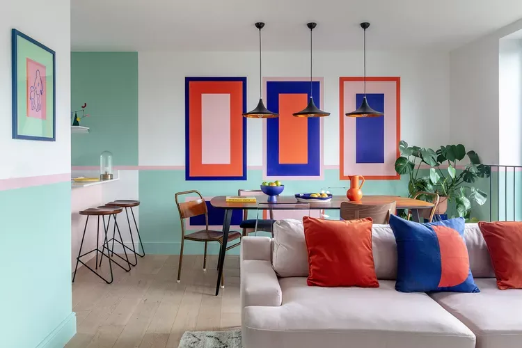 Pink, royal blue, and red-orange decor add decorative pops of color and dopamine decor to a small living space