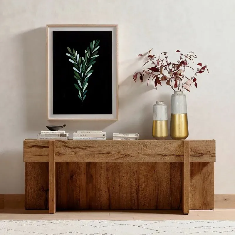 Botanical heart print next to gold and white vases on top of a wooden console table