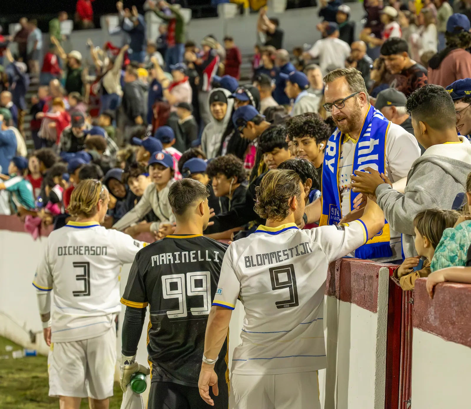 Three Westchester players including Luca Marinelli greet fans after a soccer match