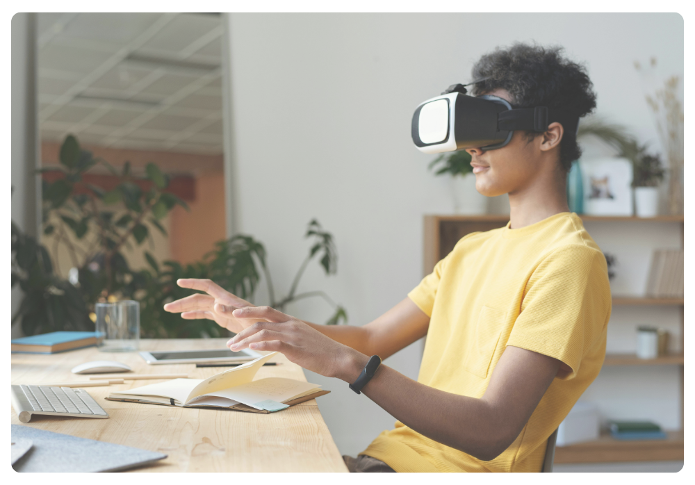 Teen using a VR headset at a desk with open books and a laptop, demonstrating how screen time can support learning and homework in creative or immersive ways.