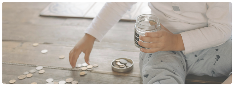 Child counting coins practicing financial literacy