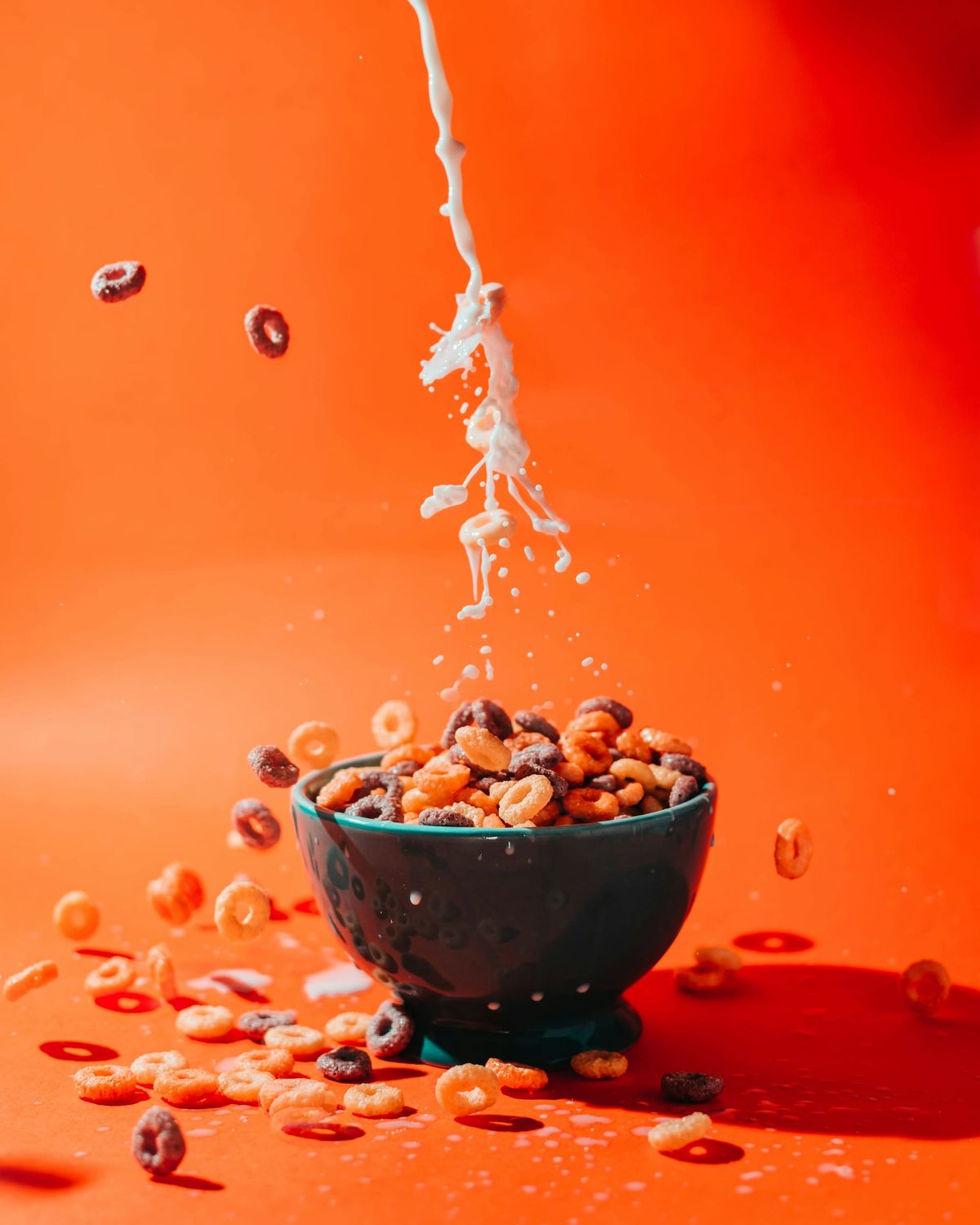 Milk splashed as it's poured into a bowl of cereal.