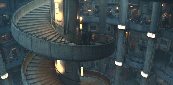 An image of a large spiral staircase, surrounded by various levels of an underground city.