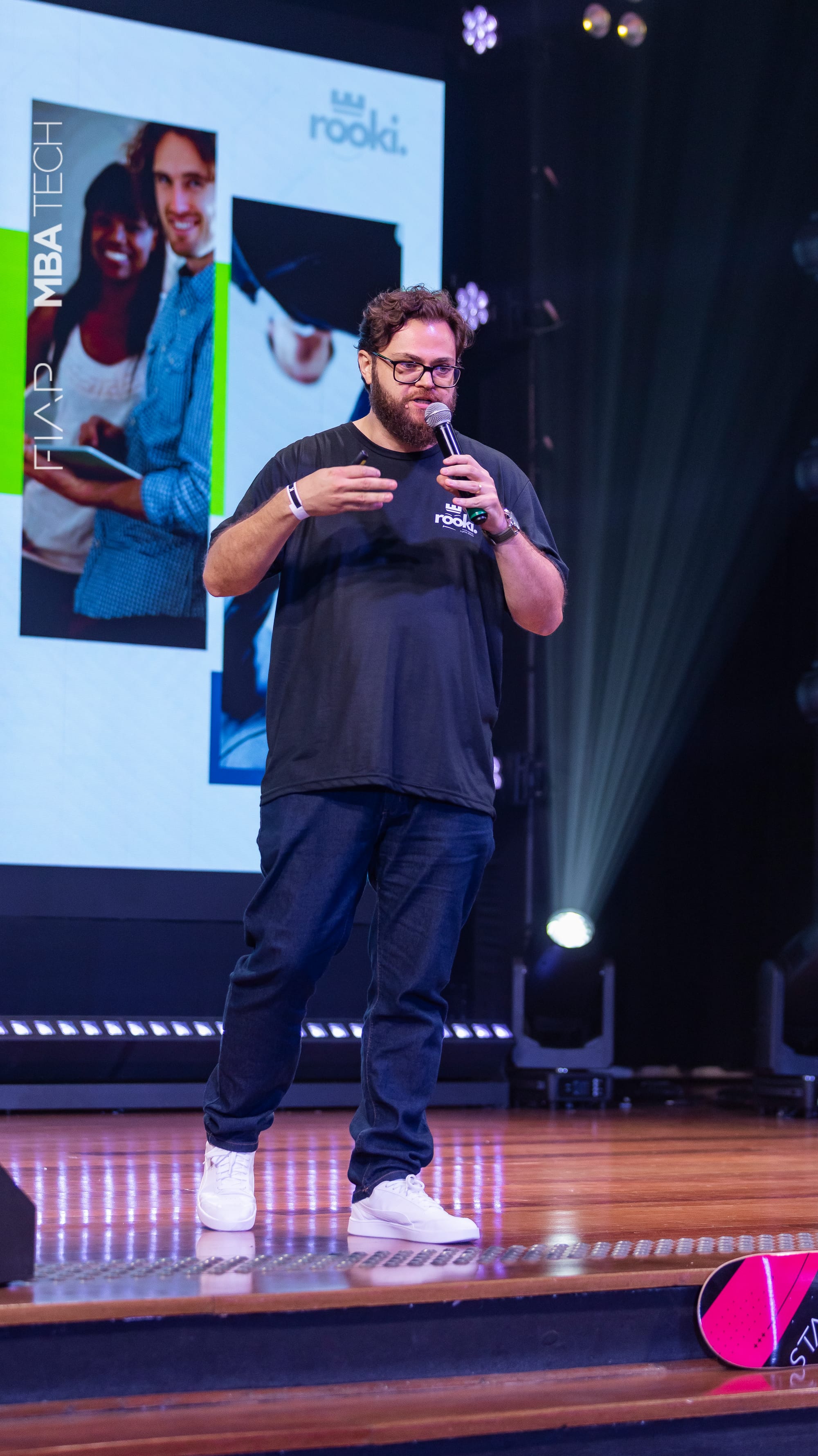 Vitão Fernandes speaking on stage at a technology event.