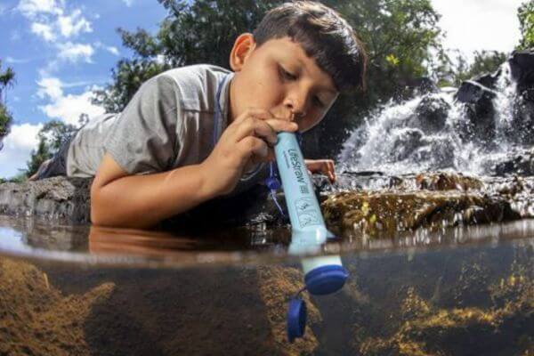 Boy Drinking Water Through A Portable Water Filter