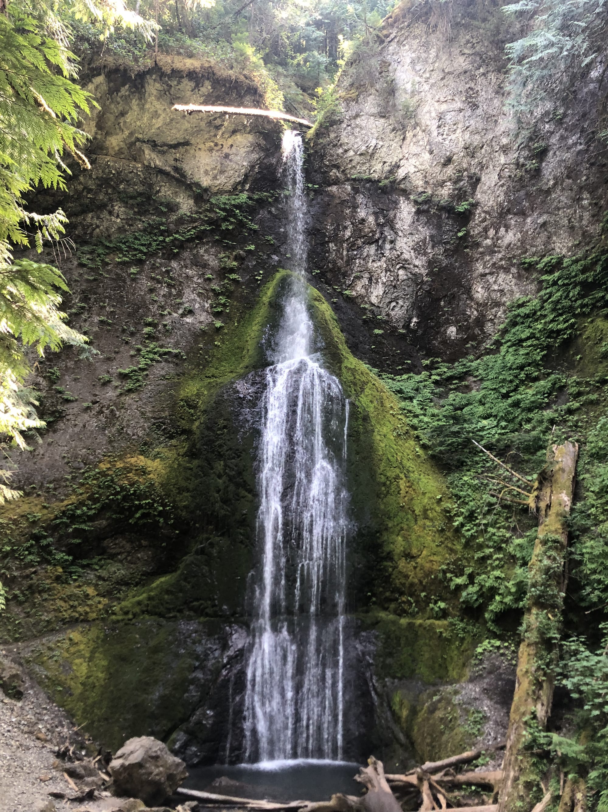 a waterfall cascading sensually down between rock covered in moss
