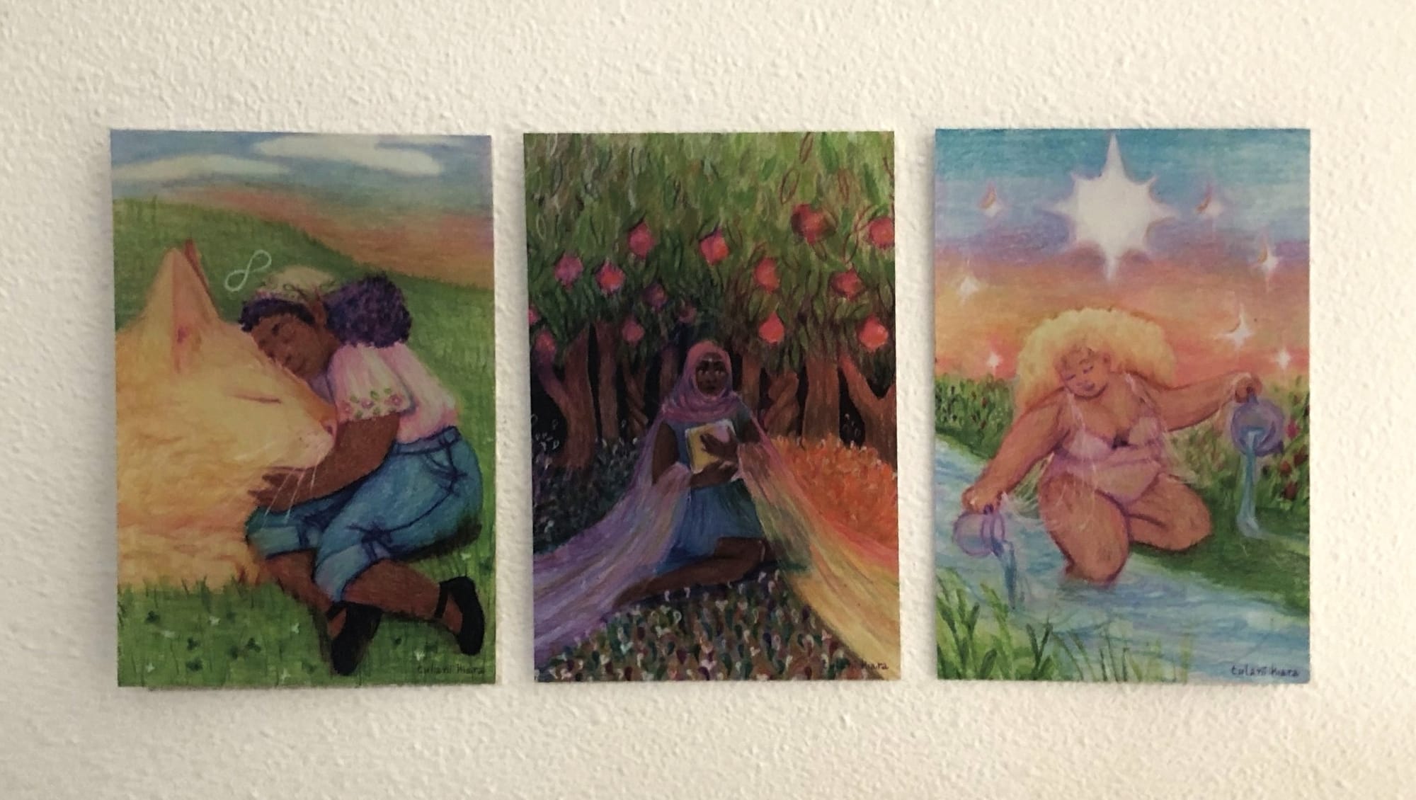 three postcards by tulani kiara mounted on a wall, depicting queer Black figures in mythological settings inspired by the tarot