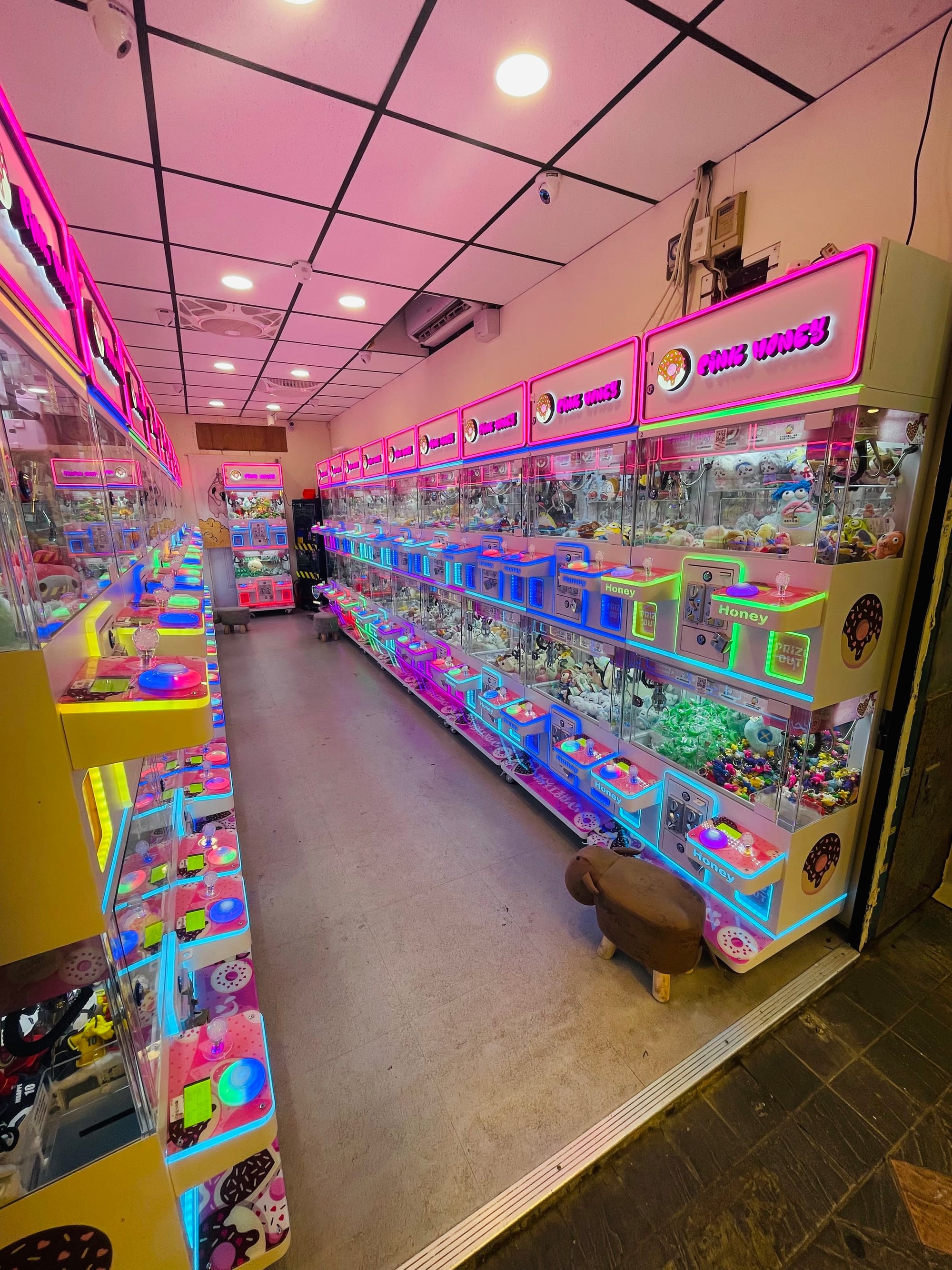 Neon pink and colorful gatcha machines in an alley in Taipei.