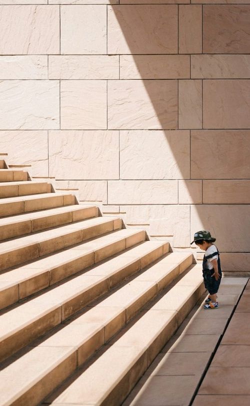 A small child at the bottom of some steep steps