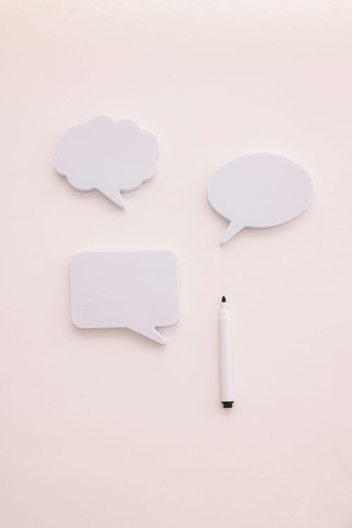3 types of post-it notes shaped as speech bubbles and a pen.