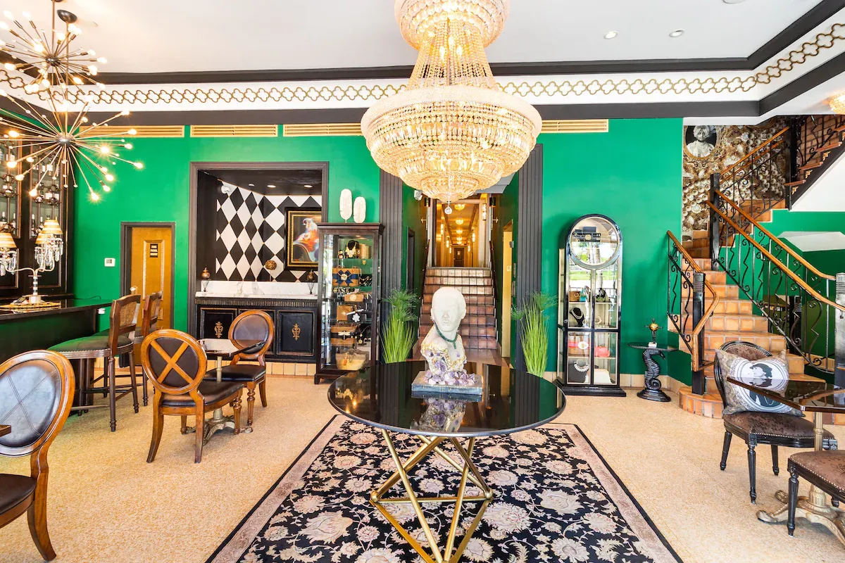Elegant Art Deco lobby of The Cavalier Hotel in Miami Beach with green walls, chandelier, and vintage decor