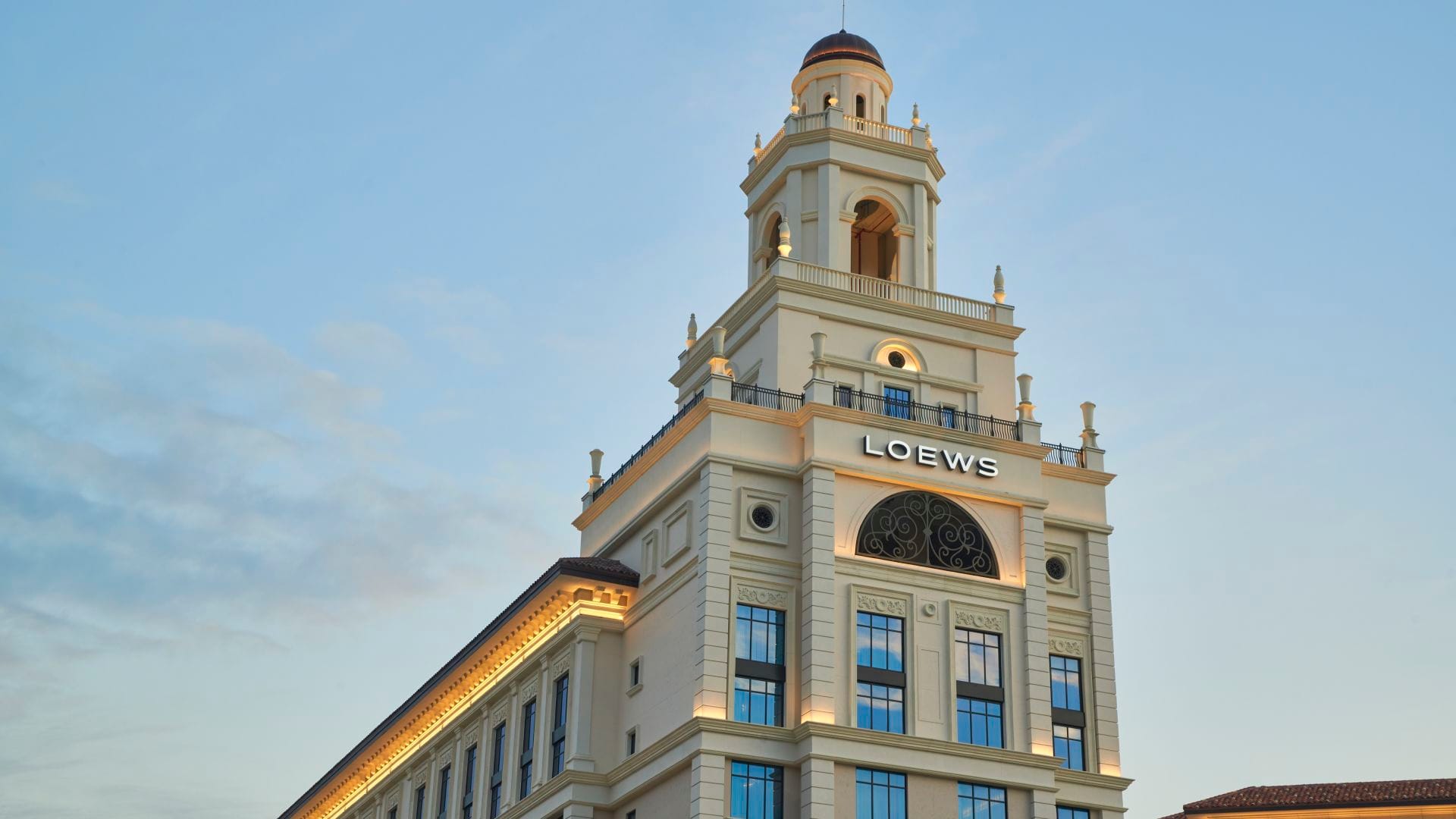 Exterior of Loews Coral Gables showcasing Spanish-inspired architecture with arches, balconies, and warm stucco.