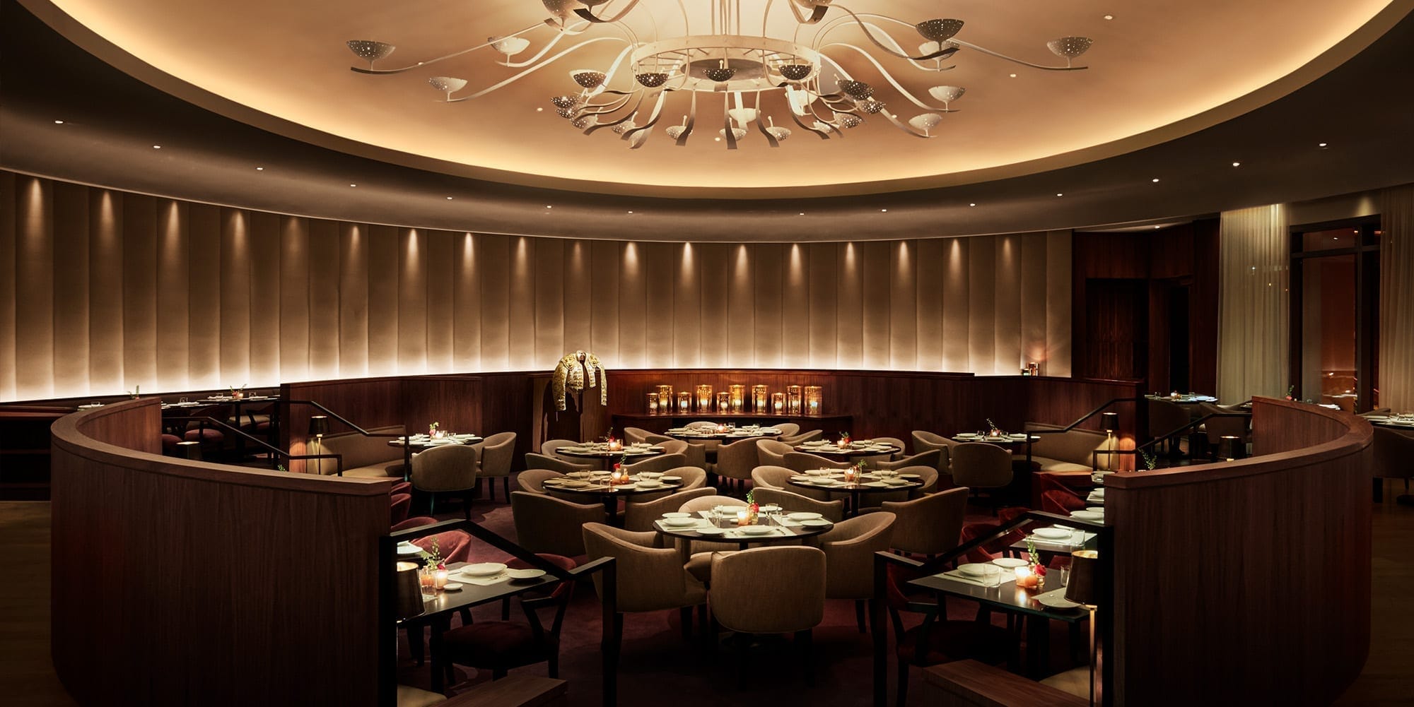 Matador Room at The Miami Beach EDITION with oval sunken dining and vintage chandelier.