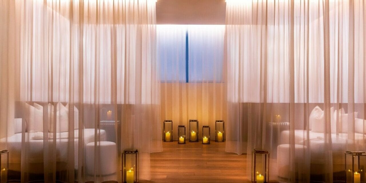The Miami Beach EDITION Spa relaxation lounge with sheer drapes and candle lanterns