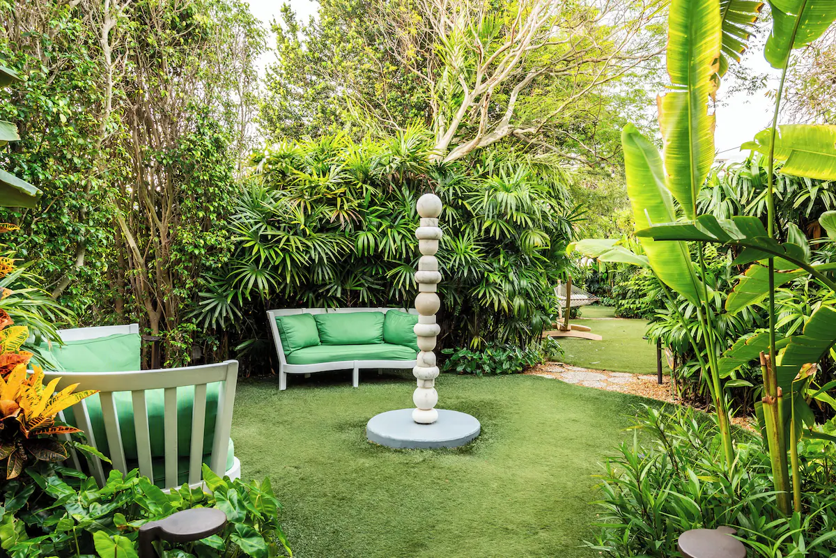Tranquil garden seating area at The Standard Spa, Miami Beach with cushioned chairs tucked among tropical greenery.