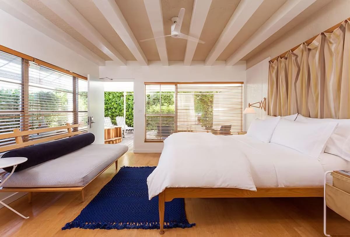 Cozy mid-century room at The Standard Spa, Miami Beach with warm wood tones, modern comforts, and minimalist décor.