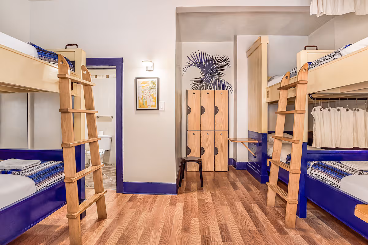 Spacious bunk room at Freehand Miami with sofa, wooden ladders, and modern dorm beds in the best hostel in Miami Beach
