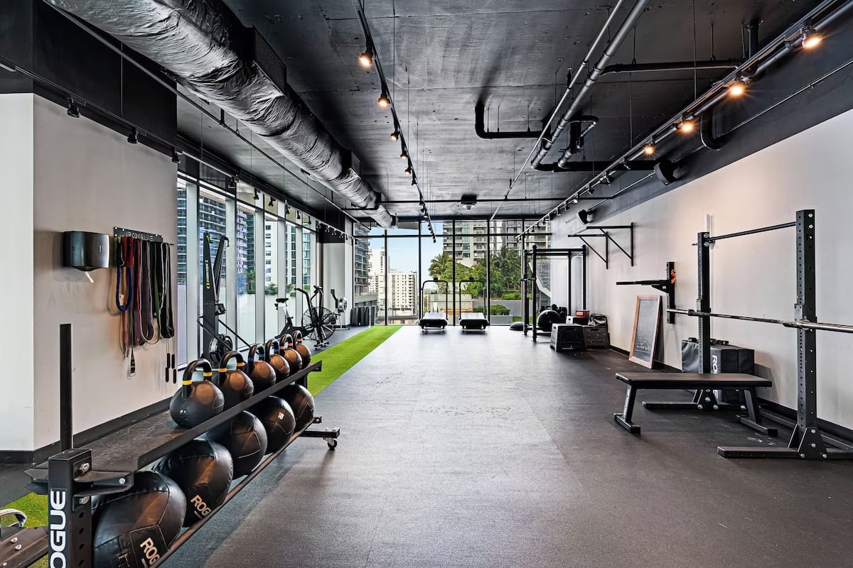 24-hour functional training gym at EAST Miami in Brickell with free weights, kettlebells, turf area, and skyline views.