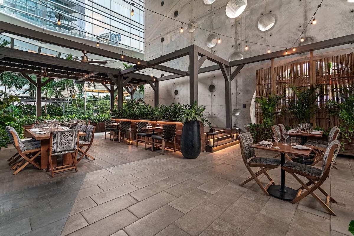 Outdoor dining area at Quinto restaurant inside EAST Miami in Brickell, featuring modern Latin-inspired cuisine, garden seating, and a luxury hotel atmosphere.