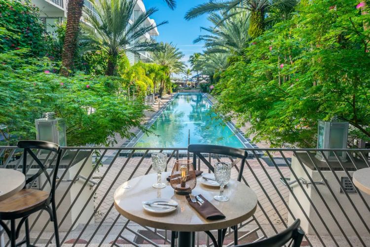 Outdoor dining terrace overlooking the infinity pool at National Hotel, an adults-only oceanfront resort in Miami Beach