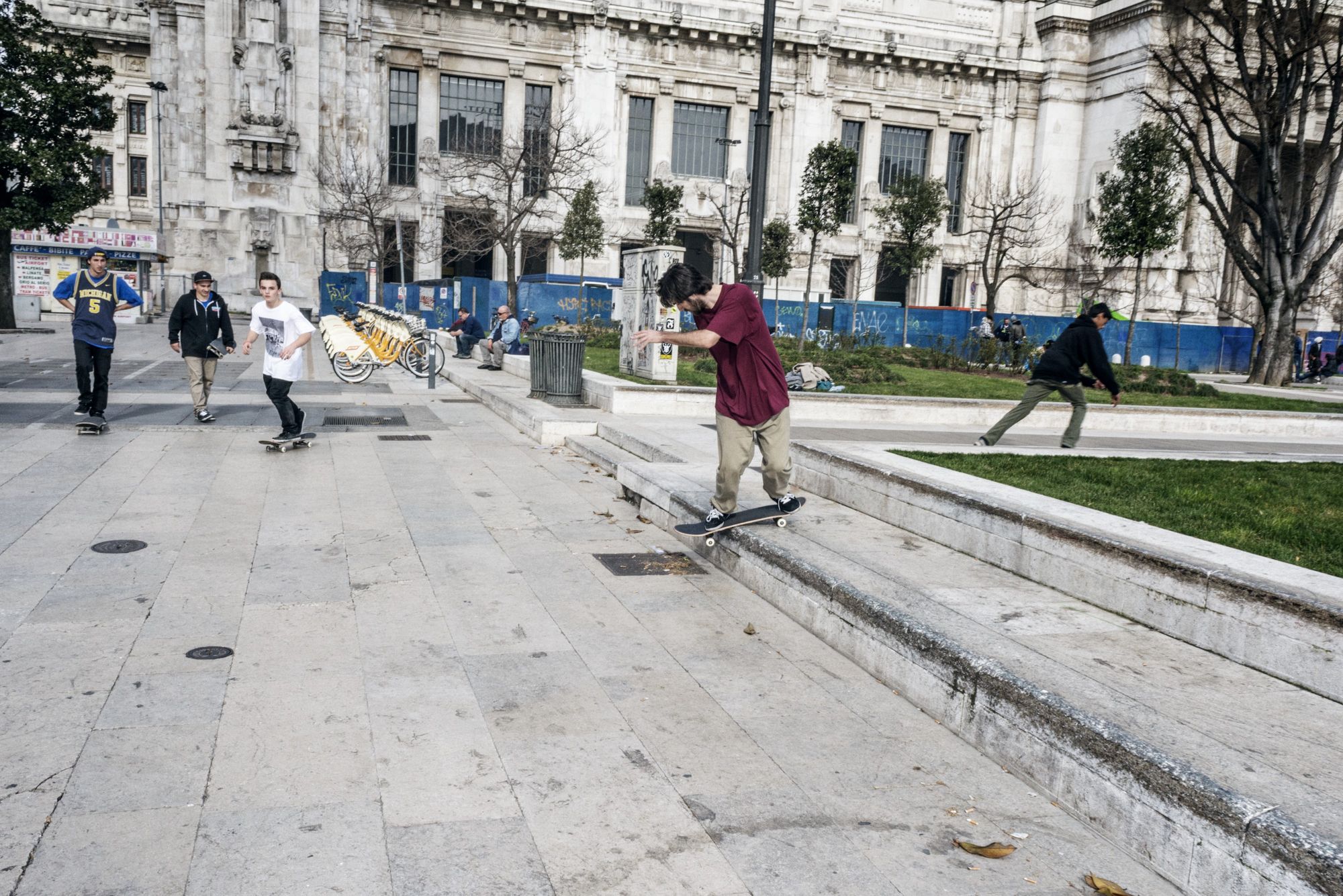 Uno skateboarder esegue un trick davanti alla Stazione Centrale di Milano