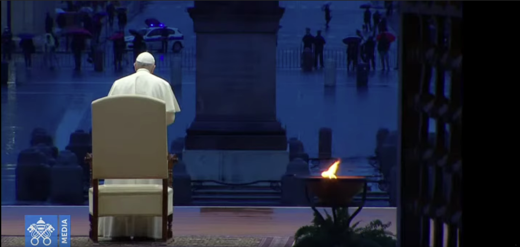 La foto raffigura un frame del video dell'indulgenza plenaria concessa da Papa Francesco. Vi si vede il Papa, ripreso di spalle, davanti allo sfondo della piazza. La scena è alterata dalla prospettiva