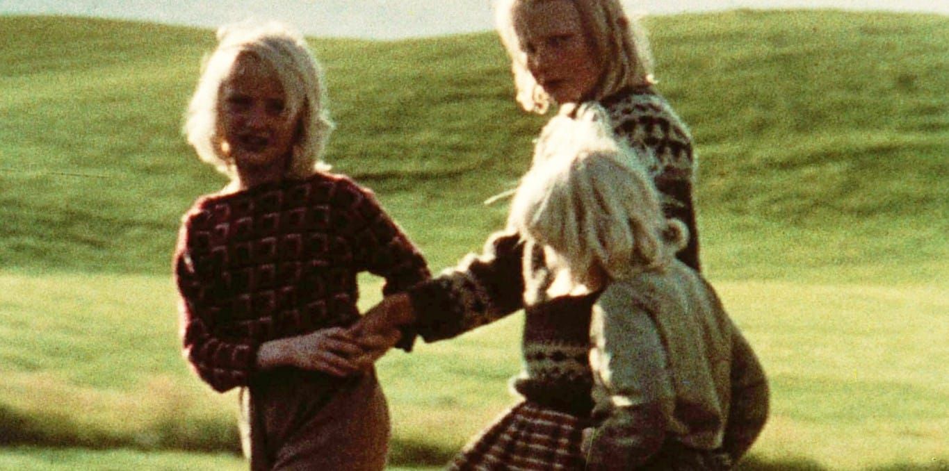 Tre bambini su un prato.