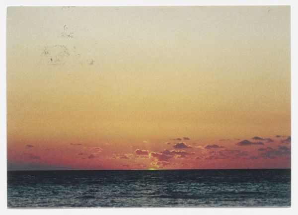 Un tramonto sul mare. Il sole emette toni di colore verde sull'acqua scura È The Green Ray dell'artista Tacita Dean.