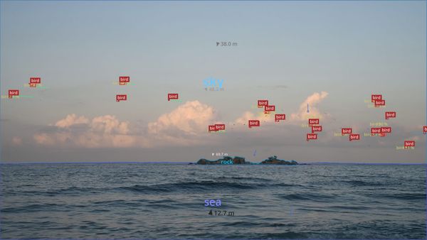 Il mare con un'isola e nubi sullo sfondo. Ogni elemento della fotografia è taggato da un software di visione macchinica.