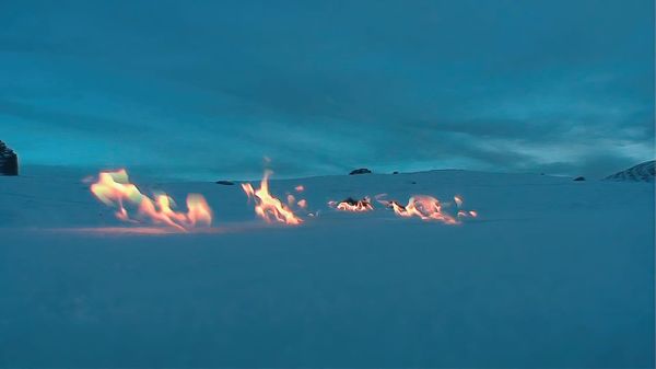 Lingue di fuoco su un terreno innevato.