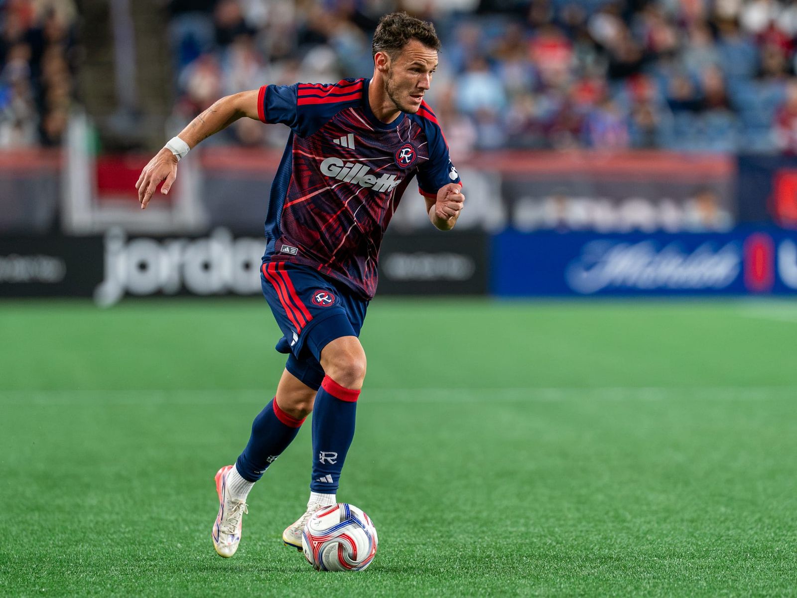 Revolution forward Daniel azdag dribbles towards goal 