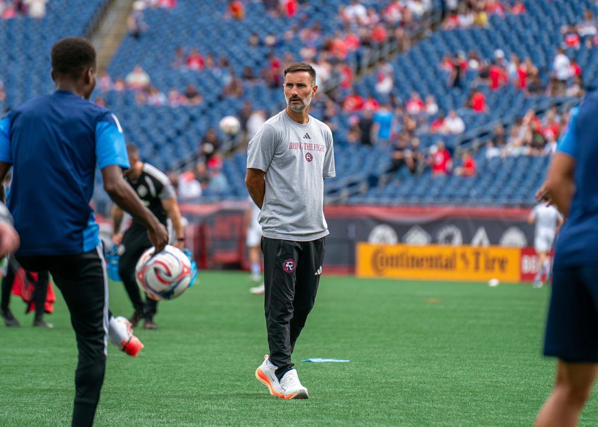 New England Revolution head coach Marko Mitrovic walks across the pitch during warm-ups (Photo By J. Alexander Dolan)