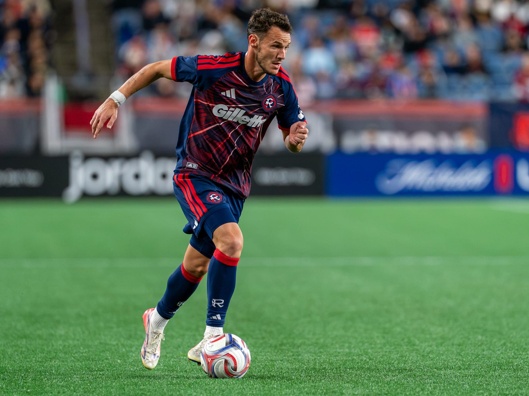 Revolution forward Daniel azdag dribbles towards goal 