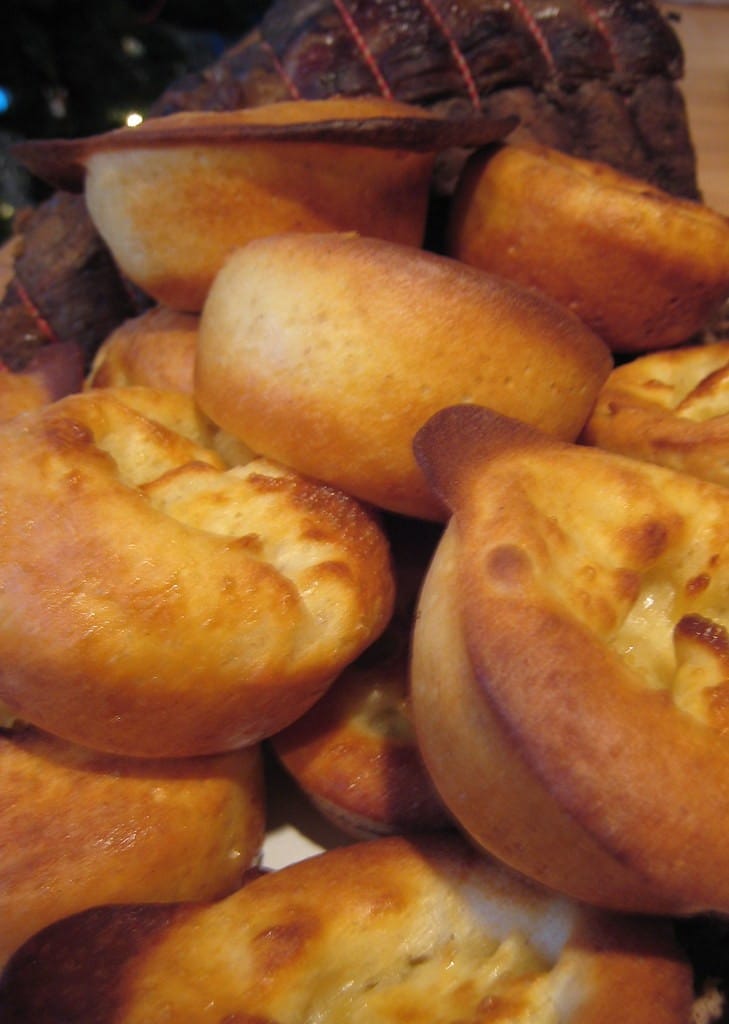 Crisp Yorkshire puddings piled beside sliced roast beef