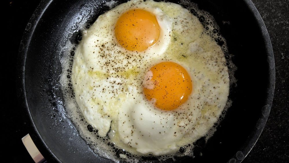 Two eggs frying in a skillet — photo for the seed-oil-free guide: Can You Fry in Butter? The Smoke Point Answer